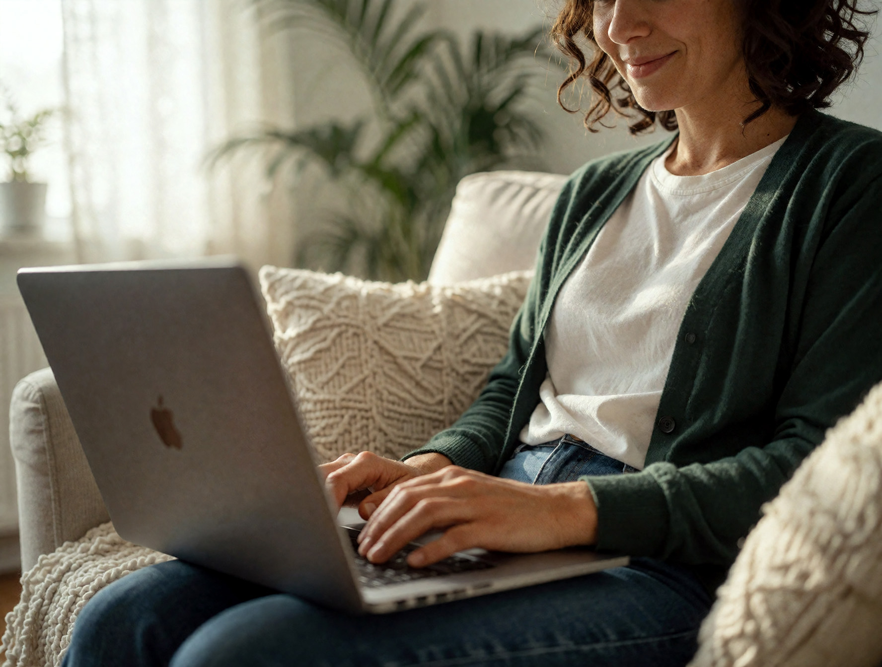 a woman with a smile indicating that she is happy with her telehealth session on a macbook
